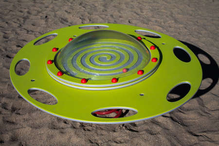 Play device UFO seesaw. A yellow plate with an acrylic cover that is attached with red half-balls.の写真素材