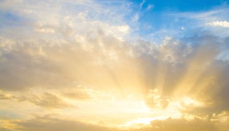 Sunset sun rays through cloudsの写真素材