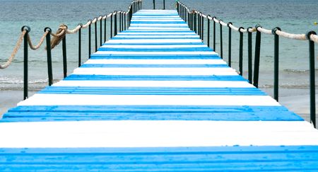 Blue and white pier goes into seaの写真素材