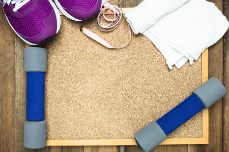 Fitness and sport equipment : sneakers,towel,bottle of water with wooden background on top viewの写真素材
