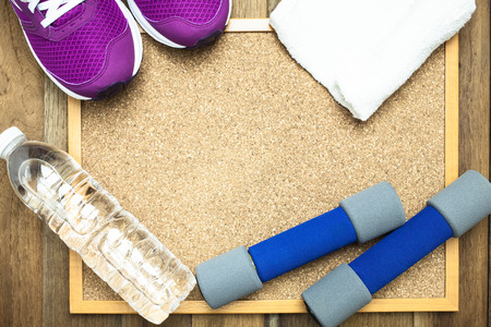 Fitness and sport equipment : sneakers,towel,bottle of water with wooden background on top viewの写真素材