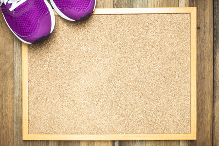Purple Sneakers on Pin board with wooden backgroundの写真素材