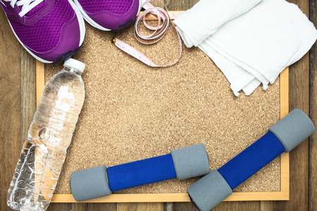 Fitness and sport equipment : sneakers,towel,bottle of water with wooden background on top viewの写真素材