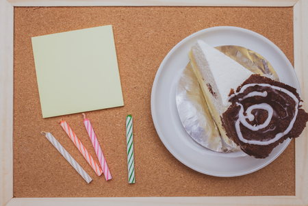 Cake,colorful candles and post it on cork board backgroundの写真素材