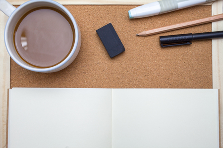 Pen,book,pencil and coffee on cork board backgroundの写真素材