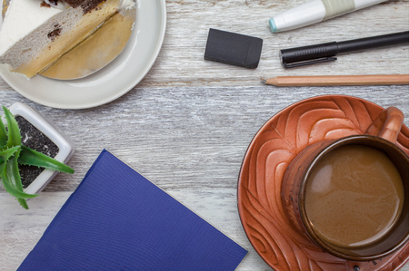 Brownie cheese cake,pen,pencil and coffee on wooden backgroundの写真素材