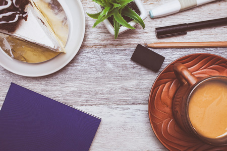Brownie cheese cake,pen,pencil and coffee on wooden backgroundの写真素材