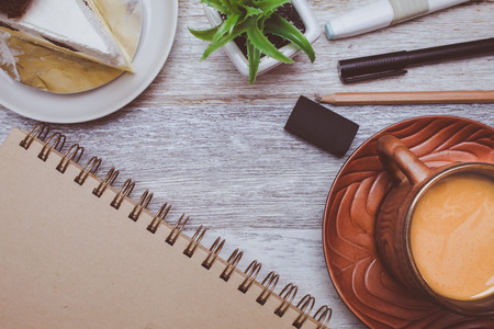 Brownie cheese cake,pen,book,pencil and coffee on wooden backgroundの写真素材