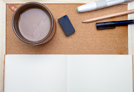 Pen,book,pencil and coffee on cork board backgroundの写真素材