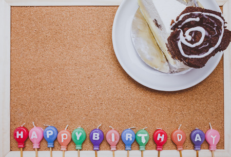 Cake and colorful Birth day candles on cork board backgroundの写真素材