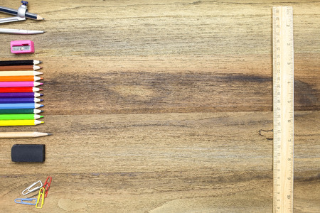 Business concept:stapler,glue,scissor,cutter,tape,pen,pencil,clip,ruler,rubber,divider,sharpener,wooden block calendar and color pencil on woodenの写真素材