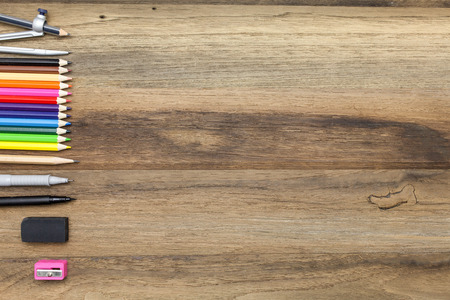 Business concept:stapler,glue,scissor,cutter,tape,pen,pencil,clip,ruler,rubber,divider,sharpener,wooden block calendar and color pencil on woodenの写真素材