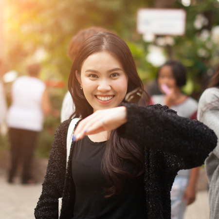 Woman enjoying Butterfly perched on her hand at the parkの写真素材