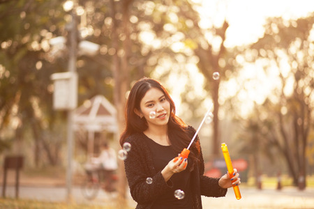 Pretty Thai girl blowing a bubbles at the parkの写真素材