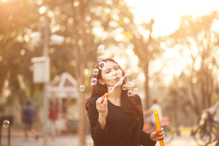Pretty Thai girl blowing a bubbles at the parkの写真素材