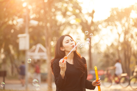 Pretty Thai girl blowing a bubbles at the parkの写真素材