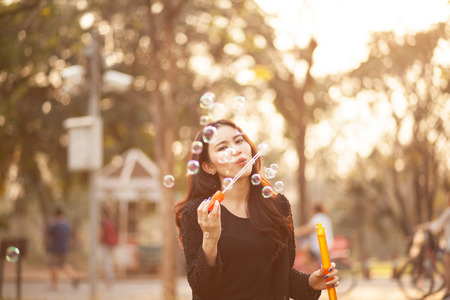 Pretty Thai girl blowing a bubbles at the parkの写真素材