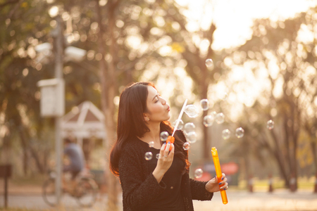 Pretty Thai girl blowing a bubbles at the parkの写真素材