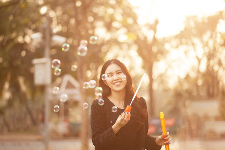 Pretty Thai girl blowing a bubbles at the parkの写真素材