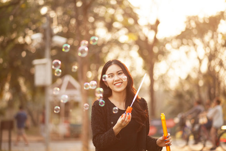 Pretty Thai girl blowing a bubbles at the parkの写真素材