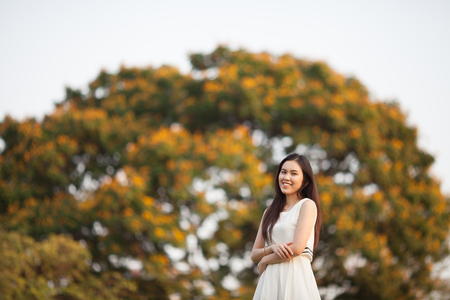 Pretty Thai girl at the park with tree blurred backgroundの写真素材