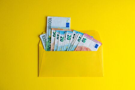 Euro banknotes in envelope on yellow background.の写真素材