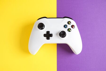 Computer gaming competition. Gaming concept. White joysticks on yellow and purple background.