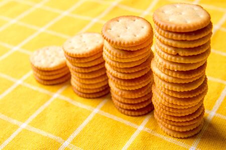 Stack Of Crackers. Pile Column. Cookie cracker. yellow tablecloth.の写真素材