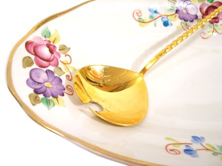 beautiful plate and golden spoon over white backgroundの写真素材