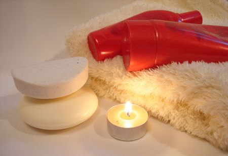 Red bottles of shower gel with soap and towelの写真素材