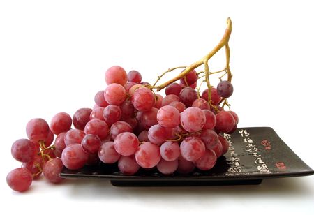 red grapes on black plate isolated の写真素材
