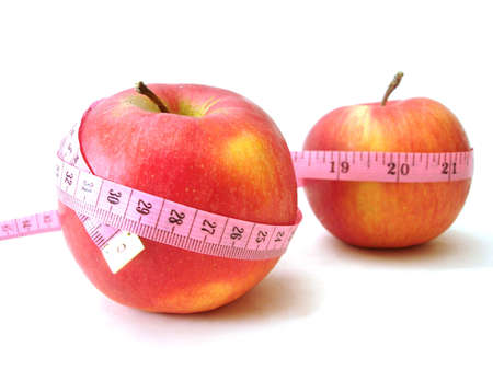 apples with pink tape measure over white background (concept of health, diet) の写真素材