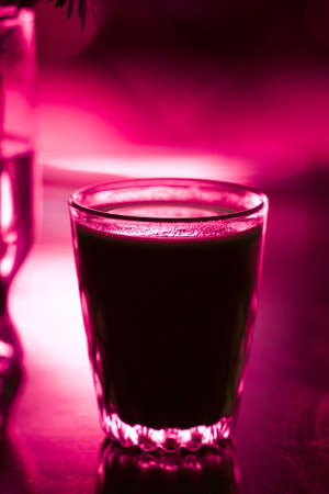 Glass with beverage on red color の写真素材