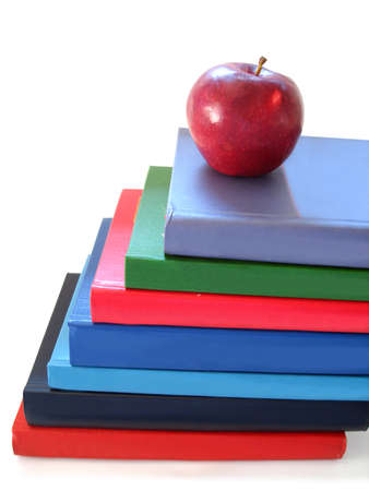 stack of books with apple over white background 