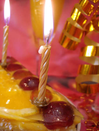 cake and golden candles on red background の写真素材