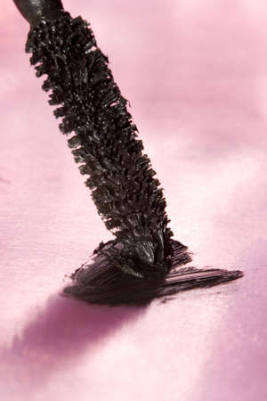 black mascara for eyes over pink background の写真素材