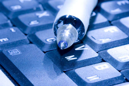 pen and computer keyboard on blue colour の写真素材