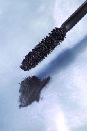 black mascara for eyes over blue background の写真素材