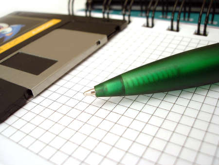 close-up of pen and diskette on notebook の写真素材