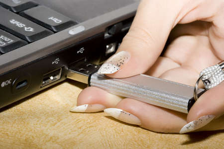 female hands inserting usb flash drive into a laptop computer の写真素材