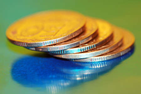 Close-up of coins on green background, macro (shallow DOF) 