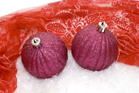 pink Christmas balls on red background with snow の写真素材