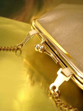 golden womanish handbag on yellow background の写真素材