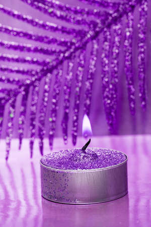 festive new-year candle with violet leaf の写真素材