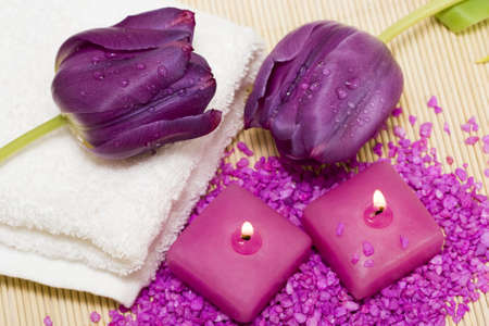 Spa essentials (candles, towel, salt and violet flowers) の写真素材