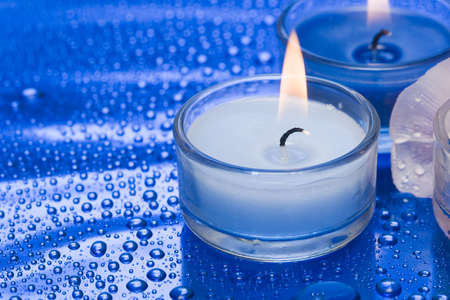 Candles with flower on blue background の写真素材