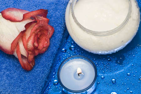 cream, candle with rose on blue background の写真素材