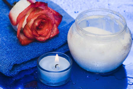 cream, candle with rose on blue background の写真素材