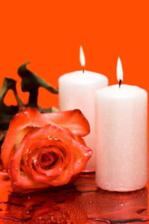 Candle with rose on red background の写真素材