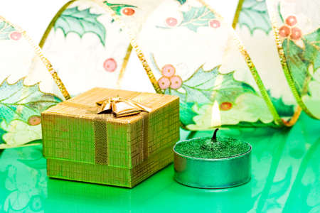 golden gift box and burning candle の写真素材